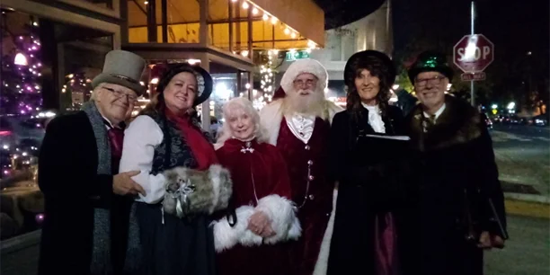group of carolers in front of Aioli restaurant in The Handle District